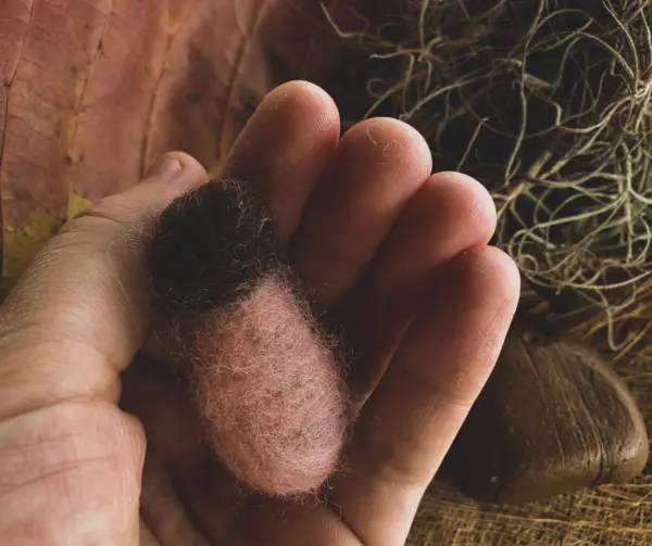 Mãos segurando lã feltrada